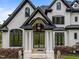 Grand front entrance to a luxury home with white columns, dark trim, and a double door entrance with transom window at 2220 Inwood Landing Ct, Raleigh, NC 27603
