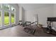 Bright home gym featuring ample windows, stationary bike, weights, and a mirror for at-home workouts at 2220 Inwood Landing Ct, Raleigh, NC 27603