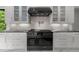 Modern kitchen featuring a professional-grade range, black countertops, subway tile backsplash, and custom cabinetry at 2220 Inwood Landing Ct, Raleigh, NC 27603