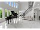Bright living room features a grand piano, high ceilings, fireplace, and staircase, creating an inviting atmosphere at 2220 Inwood Landing Ct, Raleigh, NC 27603