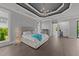 Luxury main bedroom features tray ceiling with a chandelier, hardwood floors, and an ensuite mini-bar at 2220 Inwood Landing Ct, Raleigh, NC 27603