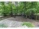 Serene backyard featuring mature trees, a gravel area, and rustic wood accents, perfect for outdoor living at 2325 Old Oak Pl, Hillsborough, NC 27278