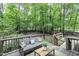 Cozy wooden deck overlooking a lush, tree-filled backyard, complete with seating for relaxation and outdoor enjoyment at 2325 Old Oak Pl, Hillsborough, NC 27278