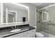 Modern bathroom featuring a glass shower, a sleek vanity with dark countertop and updated fixtures at 2325 Old Oak Pl, Hillsborough, NC 27278