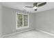 Neutral bedroom featuring a ceiling fan, a double window with wooded views at 2325 Old Oak Pl, Hillsborough, NC 27278