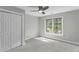 Neutral bedroom featuring a ceiling fan, a double window with wooded views, and a closet at 2325 Old Oak Pl, Hillsborough, NC 27278