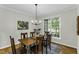 Formal dining room with natural light and wooden table set, adjacent to a window overlooking green scenery at 2325 Old Oak Pl, Hillsborough, NC 27278