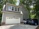 A gray single Gathering home with an attached garage and a large driveway in a wooded location at 2325 Old Oak Pl, Hillsborough, NC 27278