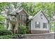 Charming two-story home with a brick and gray siding exterior, surrounded by lush greenery and trees at 2325 Old Oak Pl, Hillsborough, NC 27278