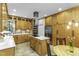 Well-lit kitchen featuring custom wood cabinets, island with cooktop, and stainless steel appliances at 2325 Old Oak Pl, Hillsborough, NC 27278