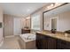 Bathroom featuring a soaking tub, granite countertop vanities, and neutral tile flooring at 2333 Lantern Walk Ln, Wake Forest, NC 27587