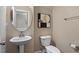 Cozy half bathroom with a pedestal sink, toilet, and decorative accents at 2333 Lantern Walk Ln, Wake Forest, NC 27587