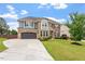 Impressive two-story home with stone and brick facade, well-manicured lawn, and large driveway at 2333 Lantern Walk Ln, Wake Forest, NC 27587
