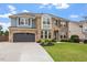 Striking front elevation with stone and brick detailing, attached garage, and landscaped yard at 2333 Lantern Walk Ln, Wake Forest, NC 27587