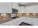Modern kitchen with stainless steel microwave, granite countertops, tile backsplash and white cabinets at 2333 Lantern Walk Ln, Wake Forest, NC 27587