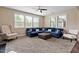 Bright living room with large windows, plush blue sofa and neutral accents at 2333 Lantern Walk Ln, Wake Forest, NC 27587