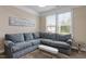 Comfortable living room with a plush sectional sofa, carpet and large windows at 2333 Lantern Walk Ln, Wake Forest, NC 27587