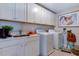 Well-organized laundry room with sink, cabinets, and modern washer and dryer for efficient chores at 2512 Stonington Dr, Cary, NC 27523