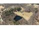 Aerial view showcasing the house, surrounding fields, and a serene pond at 2710 Morton Pulliam Rd, Roxboro, NC 27574