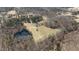 Aerial shot of a large pond surrounded by trees and fields and a home at 2710 Morton Pulliam Rd, Roxboro, NC 27574
