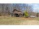 Exterior view of a weathered, old home surrounded by trees and foliage at 2710 Morton Pulliam Rd, Roxboro, NC 27574