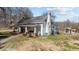 A side exterior shot of the house with a classic white exterior and well-maintained landscaping at 2710 Morton Pulliam Rd, Roxboro, NC 27574