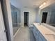 Bright bathroom with dual sinks, quartz countertop, tiled floor, and large glass-enclosed shower at 285 Gregory Village Dr, Lillington, NC 27546