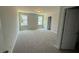 Spacious bedroom with plush carpet, natural light from windows, and a doorway to another room at 285 Gregory Village Dr, Lillington, NC 27546