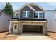 Charming new two-story home with a gray exterior, stone accents, and an attached two-car garage at 285 Gregory Village Dr, Lillington, NC 27546