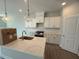 Modern kitchen with white cabinets, granite countertops, stainless steel appliances, and stylish pendant lighting at 285 Gregory Village Dr, Lillington, NC 27546
