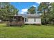 Exterior of the house with a cozy screened porch and lush green backyard, surrounded by trees at 308 Deep Creek Dr, Clayton, NC 27520