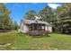 Exterior view of a house with a screened porch and spacious backyard surrounded by tall trees at 308 Deep Creek Dr, Clayton, NC 27520