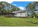 Backyard view with a well-maintained lawn, established trees, and a charming screened porch attached to the house at 308 Deep Creek Dr, Clayton, NC 27520