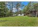 Property features a vast backyard with sheds, carport, and trailer parking, surrounded by mature trees at 308 Deep Creek Dr, Clayton, NC 27520