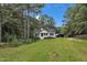 A house in the woods with a large lawn and a blue sky and trees surrounding at 308 Deep Creek Dr, Clayton, NC 27520