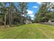 Charming single-story home featuring a well-manicured lawn surrounded by lush trees under a partly cloudy sky at 308 Deep Creek Dr, Clayton, NC 27520