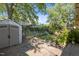 Spacious backyard with stone patio, storage shed, and lush landscaping under mature trees at 311 N Gregson St, Durham, NC 27701