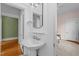 Charming bathroom with pedestal sink, wainscoting, and an open doorway to the bedroom at 311 N Gregson St, Durham, NC 27701