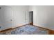Neutral bedroom with hardwood floors, colorful rug, and white doors and trim at 311 N Gregson St, Durham, NC 27701