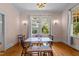 Cozy dining room featuring hardwood floors, natural light from large windows, and classic wall sconces at 311 N Gregson St, Durham, NC 27701