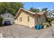 Driveway alongside the yellow house featuring a detached garage, and trash receptacles at 311 N Gregson St, Durham, NC 27701