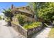 Charming yellow home with a quaint garden, fence, and brick details on the facade at 311 N Gregson St, Durham, NC 27701