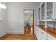 This view showcases the kitchen with an open doorway to a dining room with hardwood floors and white cabinets at 311 N Gregson St, Durham, NC 27701