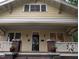 Close-up of a yellow craftsman home showing a covered front porch with brick posts at 311 N Gregson St, Durham, NC 27701