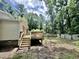 Backyard view featuring a wooden deck with stairs leading to a private, tree-lined yard with a wooden fence at 322 S Dixon Ave, Cary, NC 27511