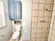 Bathroom featuring tiled shower with fixtures, toilet, and storage cabinet at 322 S Dixon Ave, Cary, NC 27511