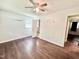 Bedroom with hardwood floors, ceiling fan, and an open doorway to an adjacent room at 322 S Dixon Ave, Cary, NC 27511