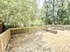 Spacious wooden deck with railing and built-in benches surrounded by lush greenery, perfect for outdoor relaxation at 322 S Dixon Ave, Cary, NC 27511
