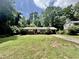 Charming single-story home with brick accents, a lush front yard and mature trees at 322 S Dixon Ave, Cary, NC 27511