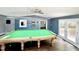 Bright game room boasts a pool table, modern lighting, and access to the back deck at 322 S Dixon Ave, Cary, NC 27511